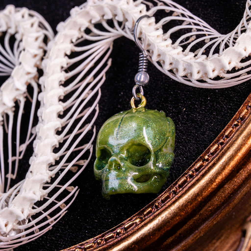 Real Viper snake skeleton taxidermy arranged in the shape of a Christmas tree, displayed on ornate gold Baroque frame with black velvet background. Decorated with colorful skull ball ornaments in red, blue, green, and pearl tones, combining gothic art with festive holiday symbolism. Perfect for dark academia interiors, oddities collectors, gothic Christmas displays, and skull lovers seeking unique handmade taxidermy art decor.