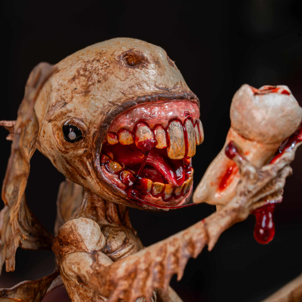 3D printed Tooth Fairy Hellboy figurine with skeletal wings, sharp claws, and a grotesque grin holding a tooth, surrounded by scattered white teeth. Hand-painted in bone, red, and brown tones, this dark fantasy collectible doubles as a tooth holder, making it perfect for gothic decor, horror props, or a unique keepsake for children’s lost teeth.