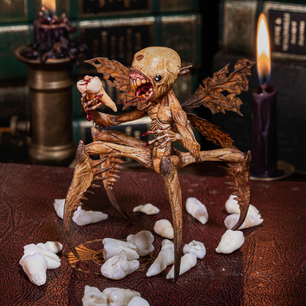 3D printed Tooth Fairy Hellboy figurine with skeletal wings, sharp claws, and a grotesque grin holding a tooth, surrounded by scattered white teeth. Hand-painted in bone, red, and brown tones, this dark fantasy collectible doubles as a tooth holder, making it perfect for gothic decor, horror props, or a unique keepsake for children’s lost teeth.