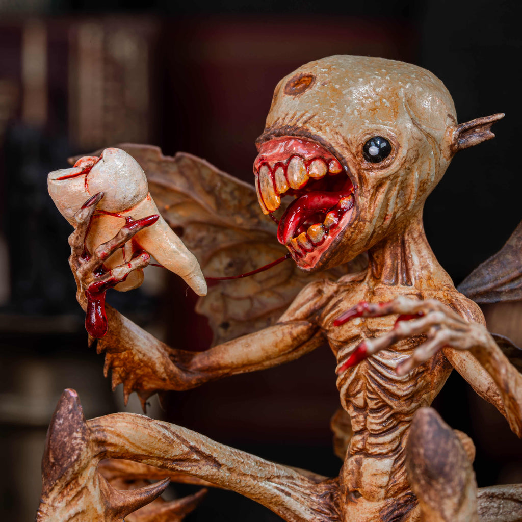 3D printed Tooth Fairy Hellboy figurine with skeletal wings, sharp claws, and a grotesque grin holding a tooth, surrounded by scattered white teeth. Hand-painted in bone, red, and brown tones, this dark fantasy collectible doubles as a tooth holder, making it perfect for gothic decor, horror props, or a unique keepsake for children’s lost teeth.